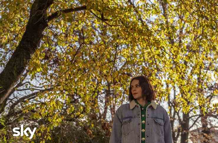 Francesca Michielin su Effetto Terra con un giacchetto di jeans immersa nel giallo delle foglie degli alberi