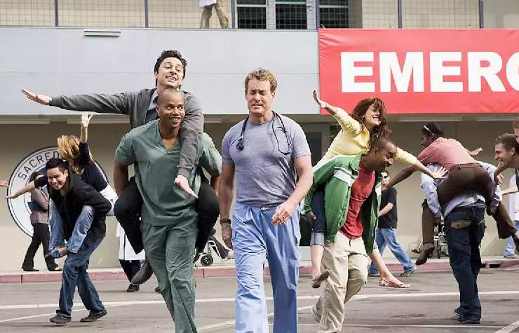 Scena di Scrubs in cui persone con divise da ospedale camminano e ballano