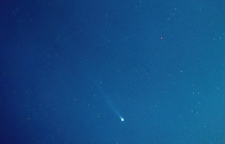 Cometa verde Nishimura che si vede in basso al cielo azzurro